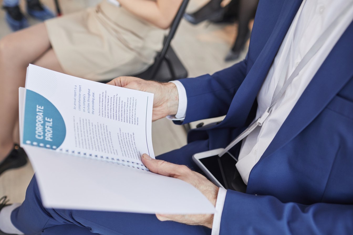 Businessman Holding Conference Pamphlet Close Up